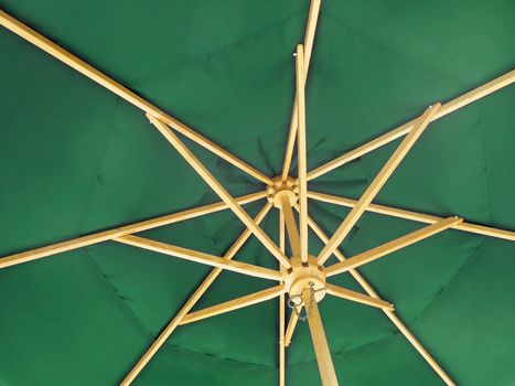 The inside of an open green umbrella