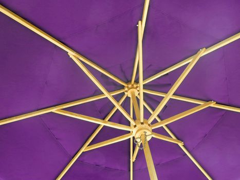 The inside of an open purple umbrella