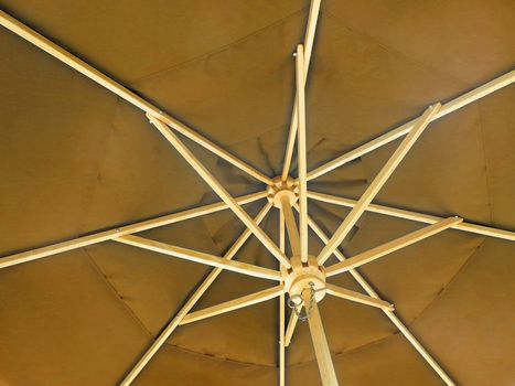 The inside of an open sandy colored umbrella