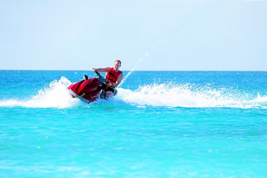 Young guy cruising on a jet ski on the caribbean sea