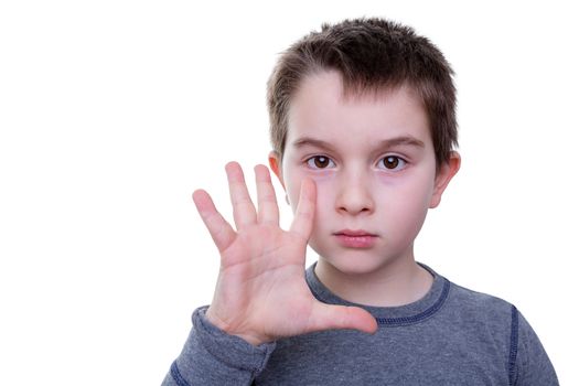 Single serious little boy gesturing with five fingers as if to count or display a symbol with an open hand