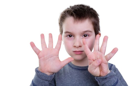 Cute serious little boy gesturing with eight fingers on two hands as if to count or display a symbol