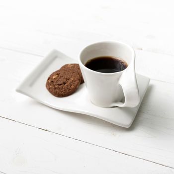 coffee cup with cookie on white wood background