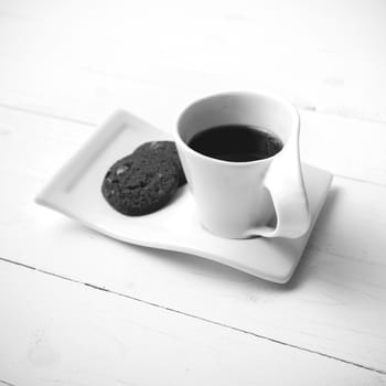 coffee cup with cookie on white wood background black and white color