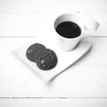 coffee cup with cookie on white wood background black and white color