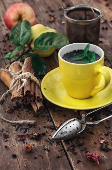 Apple tea with cinnamon on a background of custard spoons in the autumn style