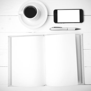 coffee cup with phone and notebook on white wood table black and white color