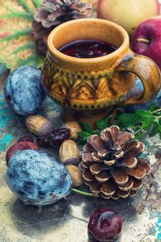 Fashion clay cup on the background of harvest of autumn fruits.