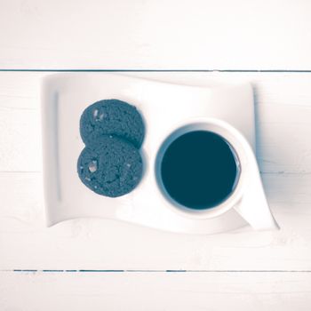 coffee cup with cookie on white wood background vintage style