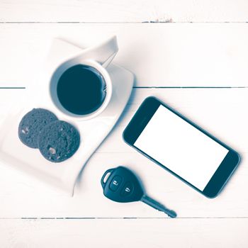 coffee cup with cookie,phone and car key on white wood table vintage style