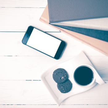 coffe cup with cookie,phone and stack of book on white wood table vintage style