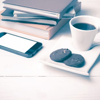 coffe cup with cookie,phone and stack of book on white wood table vintage style