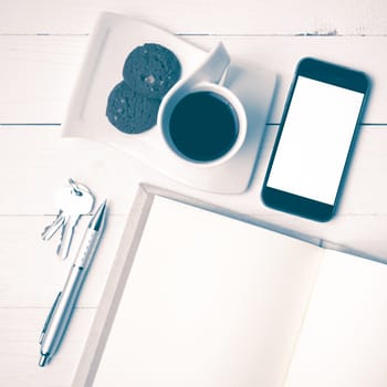 coffee cup with cookie,phone,notebook and key on white wood table vintage style