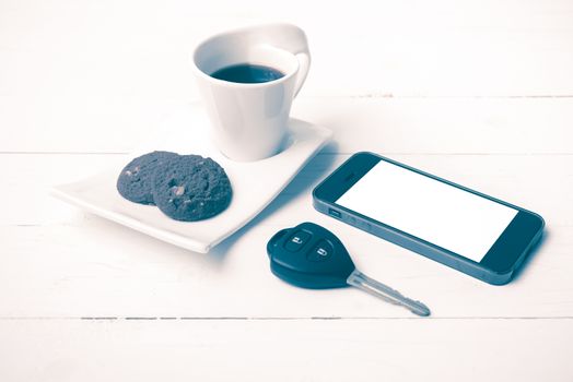coffee cup with cookie,phone and car key on white wood table vintage style