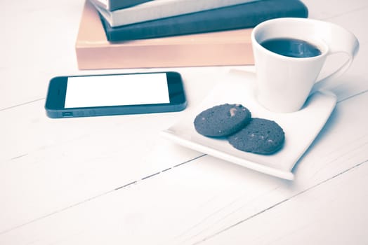 coffe cup with cookie,phone and stack of book on white wood table vintage style