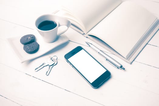 coffee cup with cookie,phone,notebook and key on white wood table vintage style