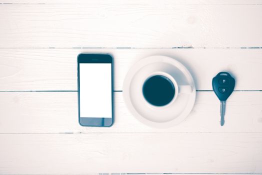 coffee cup with phone and car key on white wood table vintage style