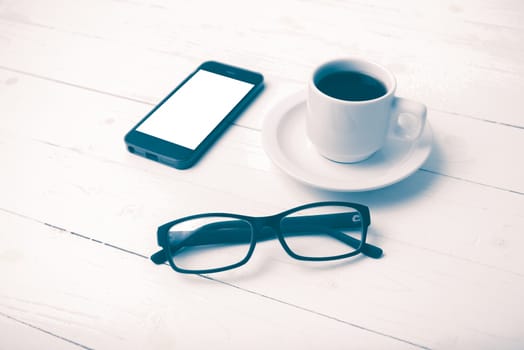 coffee cup with phone and eyeglasses on white wood table vintage style