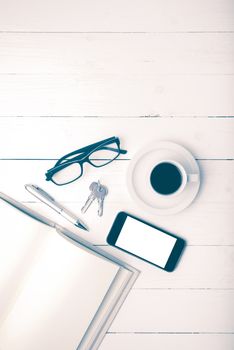 coffee cup with phone, key,eyeglasses and open notebook on white wood table vintage style