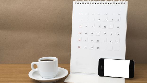 coffee cup and phone and calendar on wood background