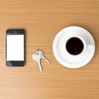 coffee cup and phone and key on wood background