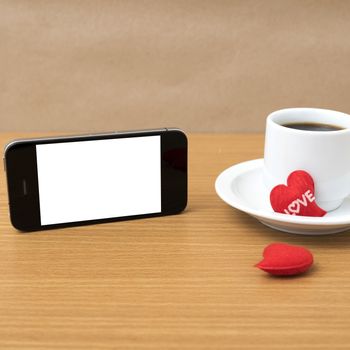 coffee cup and phone and heart on wood background