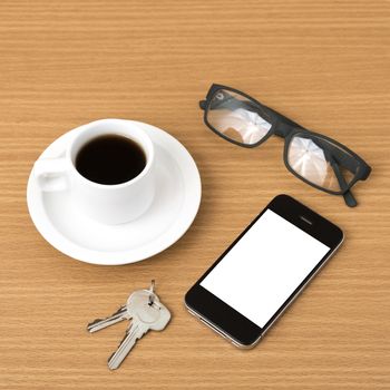 coffee cup and phone with key on wood background