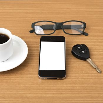 coffee cup and phone with car key on wood background