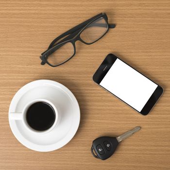 coffee cup and phone with car key on wood background
