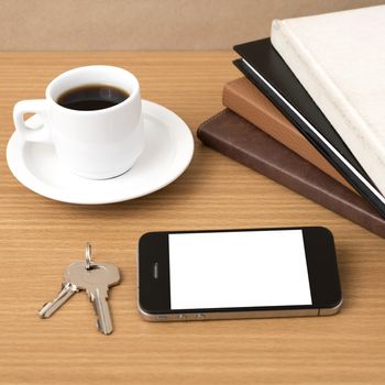 coffee cup with phone key and stack of book on wood background