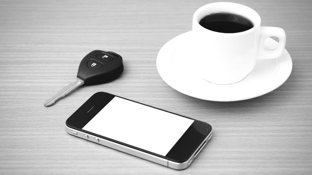 coffee cup and phone and car key on wood background black and white color