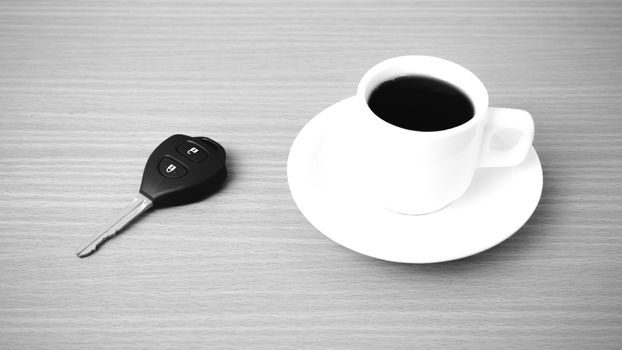 coffee cup and car key on wood background  black and white color