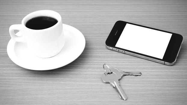 coffee cup and phone and key on wood background  black and white color