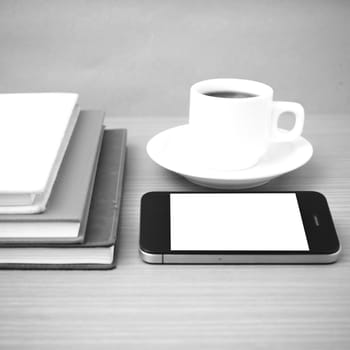 coffee cup and phone and stack of book on wood background  black and white color