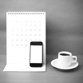 coffee cup and phone and calendar on wood background  black and white color