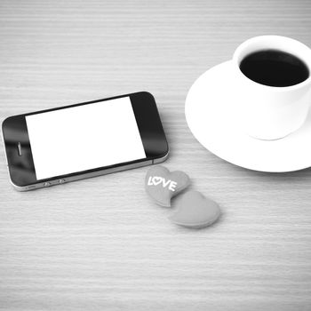 coffee cup and phone and heart on wood background black and white color