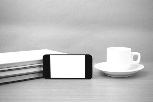 coffee cup and phone and stack of book on wood background  black and white color