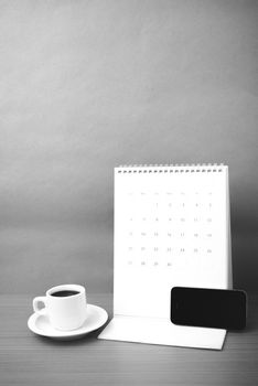 coffee cup and phone and calendar on wood background  black and white color