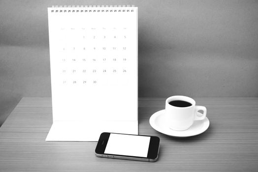 coffee cup and phone and calendar on wood background  black and white color
