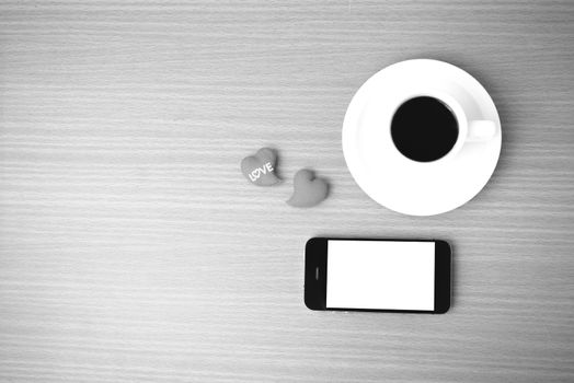 coffee cup and phone and heart on wood background black and white color