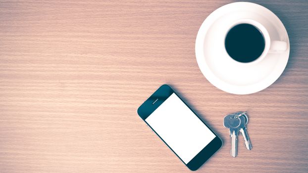 coffee cup and phone and key on wood background vintage style