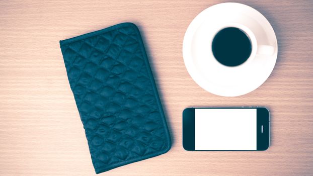 coffee cup and phone and wallet on wood table vintage style