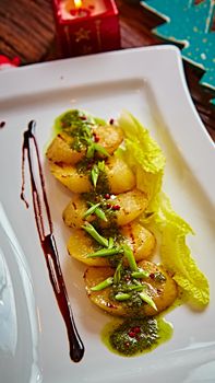 appetizer of grilled celery with greens in a white plate