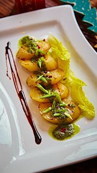 appetizer of grilled celery with greens in a white plate