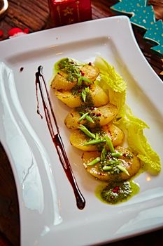 appetizer of grilled celery with greens in a white plate