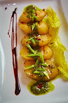 appetizer of grilled celery with greens in a white plate