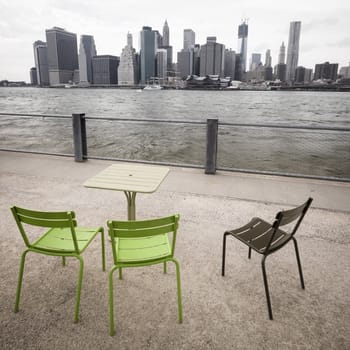 Table and chairs at the waterfront facing the Manhattan skyline