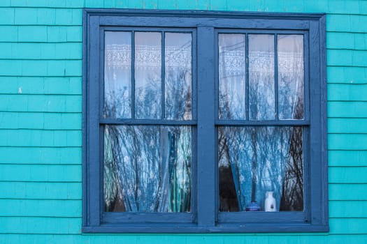 old window in old house with curtains and reflections