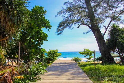 Wooden deck leading to blue water and beach