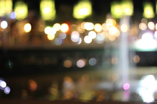 Blurred background bokeh night with a fountain.